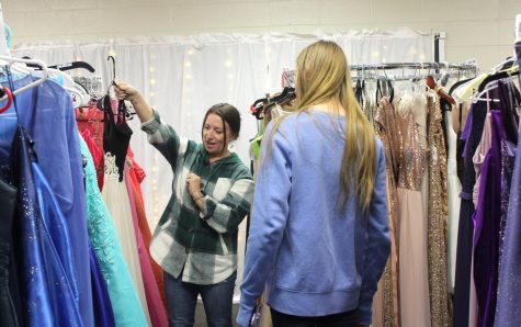 Senior Kyleigh Burke looks at a dress Ms. Bowley has picked out. Bowley is a co-sponsor of the Cinderella Shoppe, where students can borrow formal attire for a 10 dollar fee.